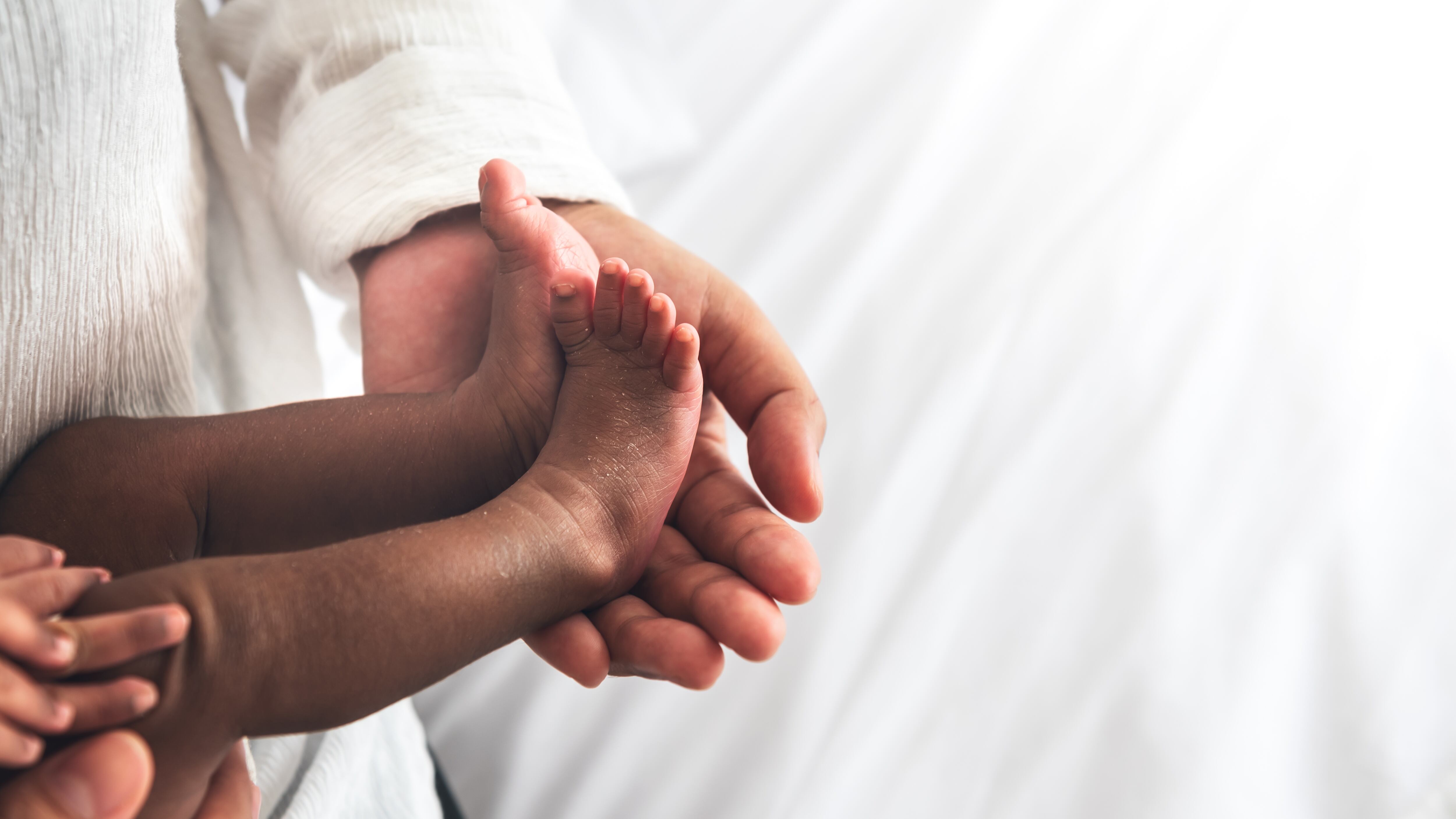 Baby's foot placed on the mother's hand.
